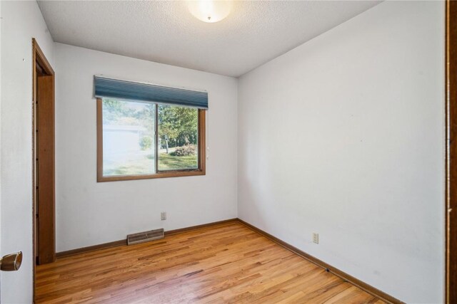 unfurnished bedroom featuring light hardwood / wood-style floors and a textured ceiling