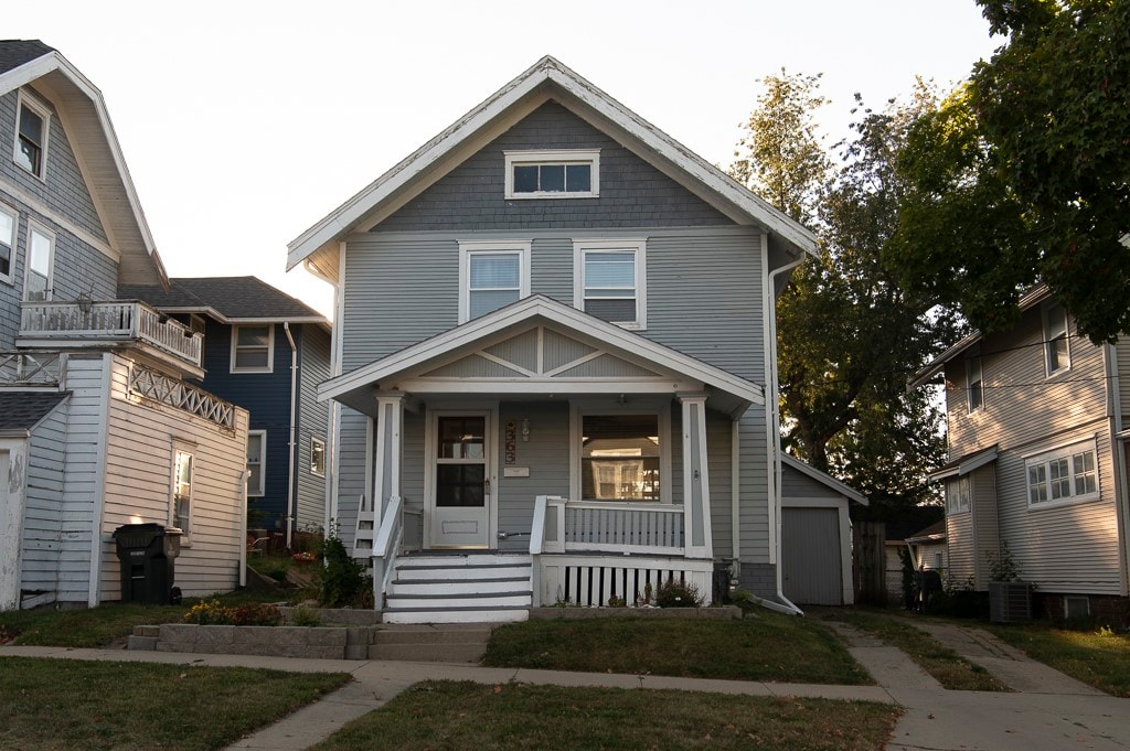 view of front of house with a porch, a storage unit, and central air condition unit