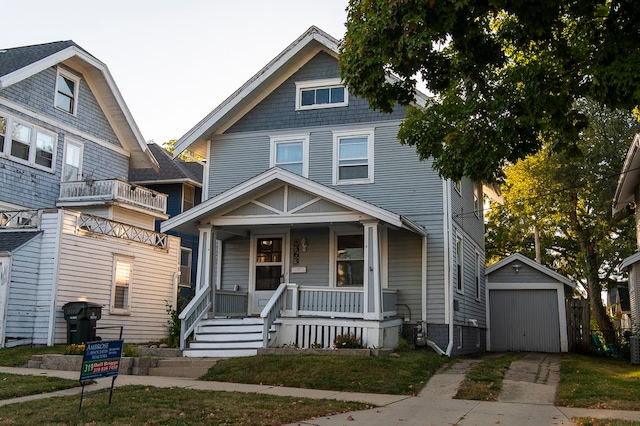 view of front of house featuring an outdoor structure, a garage, a front lawn, and covered porch