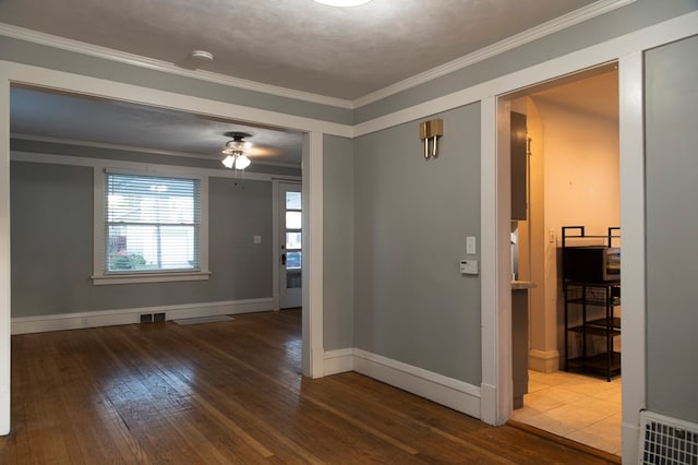 empty room featuring crown molding, hardwood / wood-style flooring, and ceiling fan