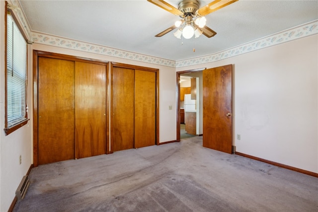 unfurnished bedroom with ceiling fan, multiple closets, light carpet, ornamental molding, and a textured ceiling