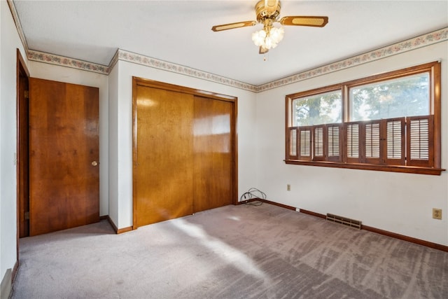 unfurnished bedroom featuring ceiling fan, a closet, and light carpet