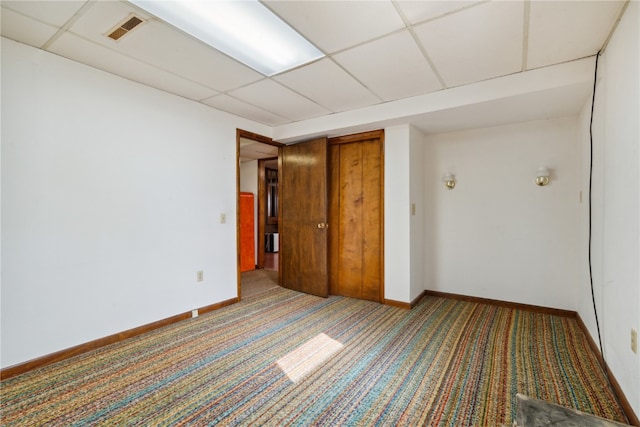 empty room with carpet floors and a paneled ceiling