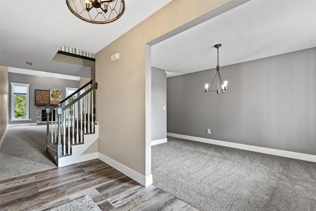 stairway featuring an inviting chandelier and hardwood / wood-style flooring