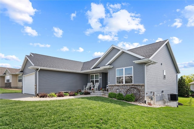 craftsman inspired home with a front yard, central AC unit, and a garage