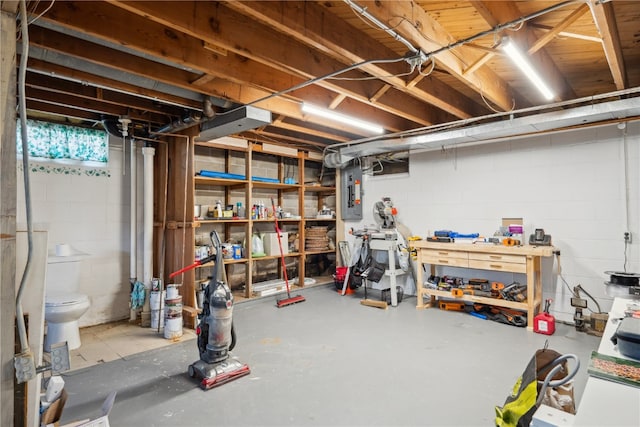 basement featuring electric panel and a workshop area