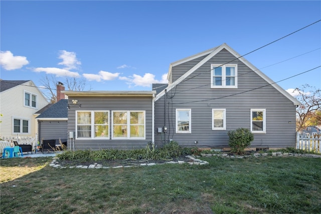 rear view of property featuring a patio area and a lawn