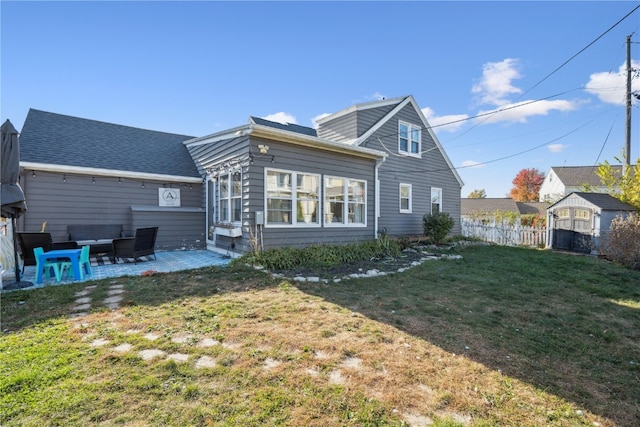 back of house with a yard, a patio area, and a storage shed