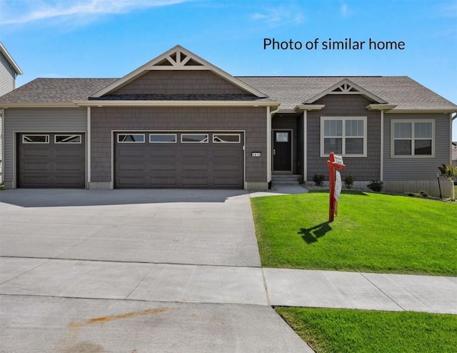 single story home with driveway, a front yard, a shingled roof, and an attached garage