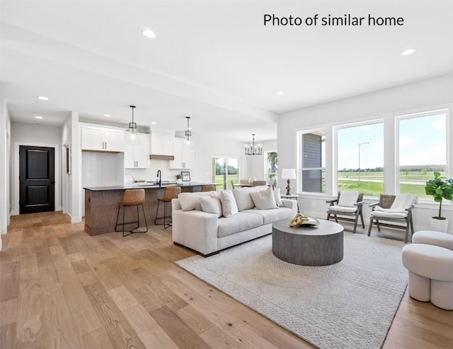 living room featuring recessed lighting, an inviting chandelier, and light wood-style floors