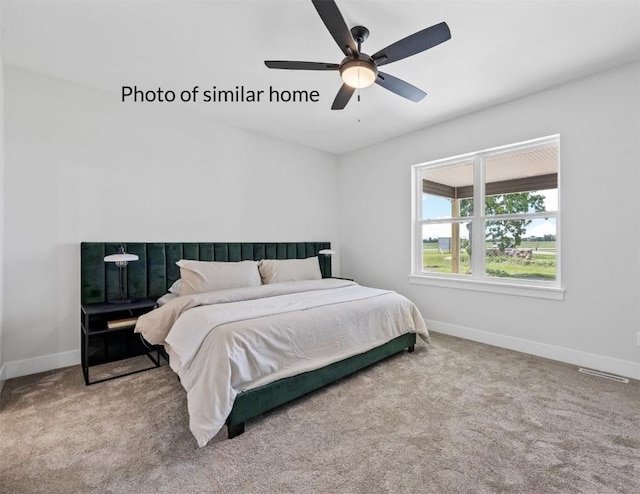 carpeted bedroom featuring a ceiling fan, visible vents, and baseboards