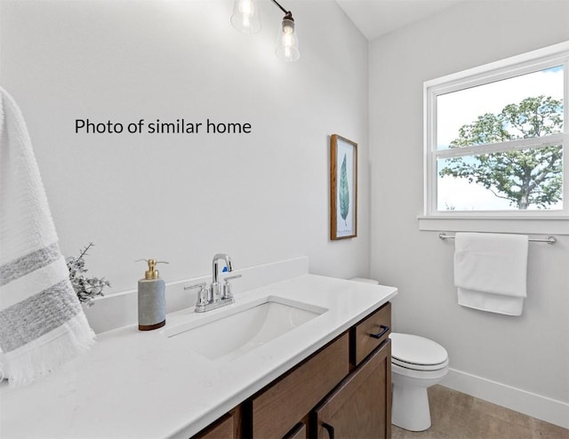 bathroom with toilet, baseboards, and vanity