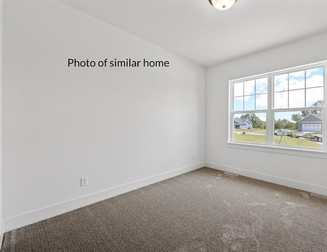 empty room with lofted ceiling, baseboards, and carpet flooring