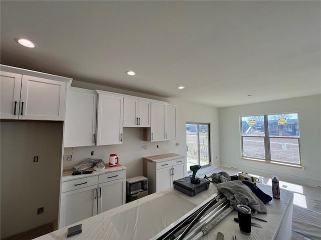 kitchen featuring light countertops, white cabinets, recessed lighting, and baseboards