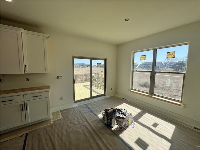 unfurnished dining area with baseboards