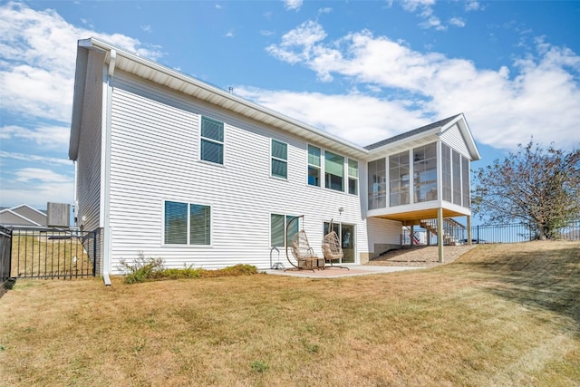 rear view of property with a yard, a patio, and a sunroom