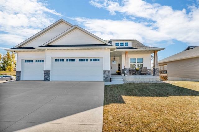 craftsman-style house featuring a front yard, a garage, and a porch