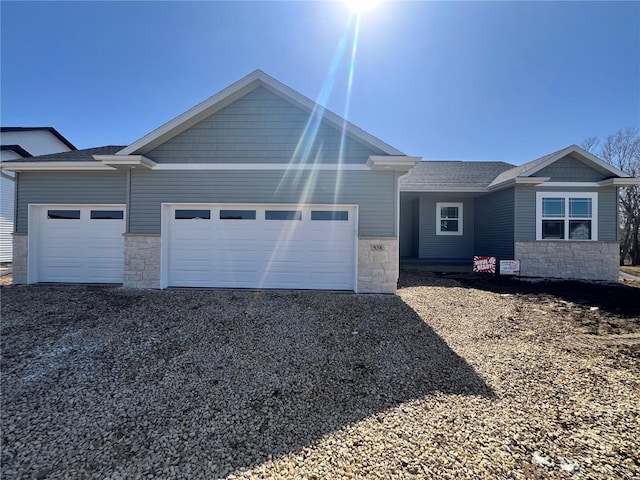 view of front of property with a garage, stone siding, and driveway