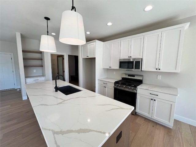 kitchen featuring recessed lighting, stainless steel appliances, light wood-style floors, white cabinetry, and a sink