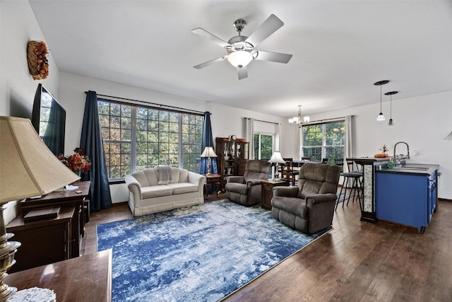 living room with sink, dark hardwood / wood-style flooring, and ceiling fan with notable chandelier