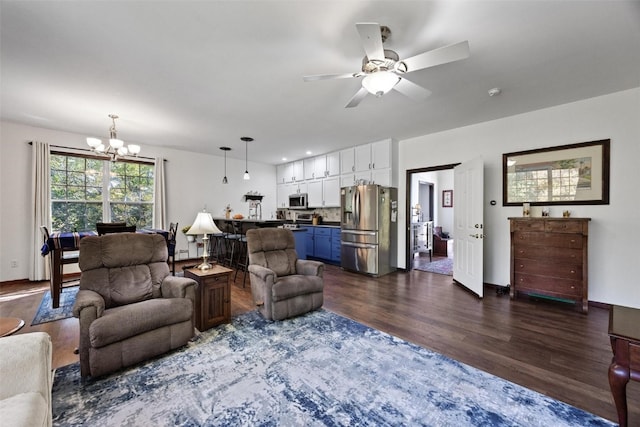 living room featuring dark hardwood / wood-style flooring and ceiling fan with notable chandelier