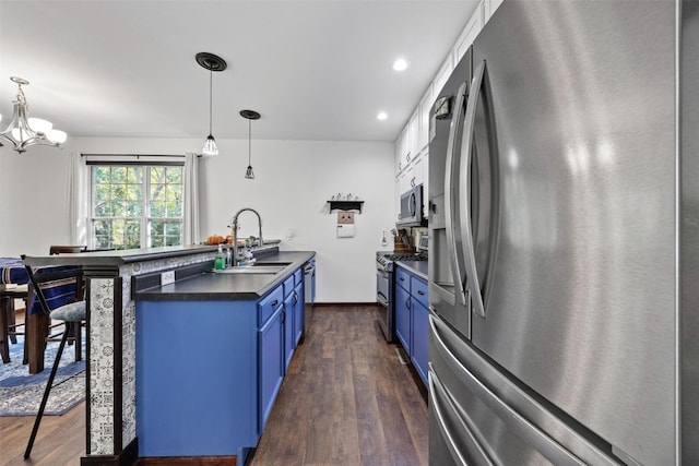 kitchen featuring blue cabinetry, dark hardwood / wood-style floors, stainless steel appliances, and decorative light fixtures