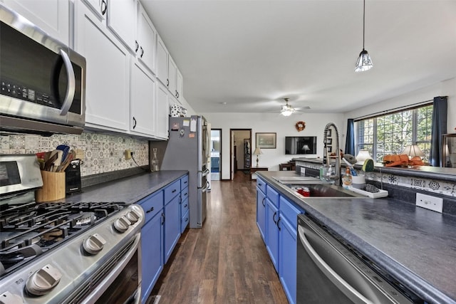 kitchen with white cabinets, hanging light fixtures, appliances with stainless steel finishes, dark wood-type flooring, and blue cabinets