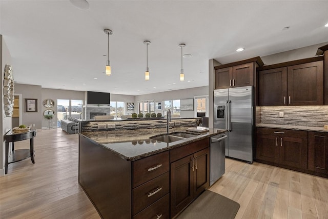 kitchen featuring light hardwood / wood-style flooring, stainless steel appliances, sink, and a wealth of natural light