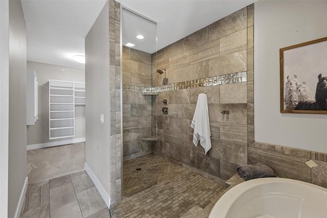 bathroom with tile walls, separate shower and tub, and tile patterned floors