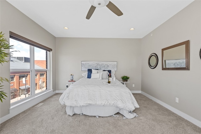 carpeted bedroom with ceiling fan and multiple windows