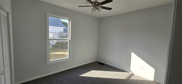 carpeted spare room featuring ceiling fan