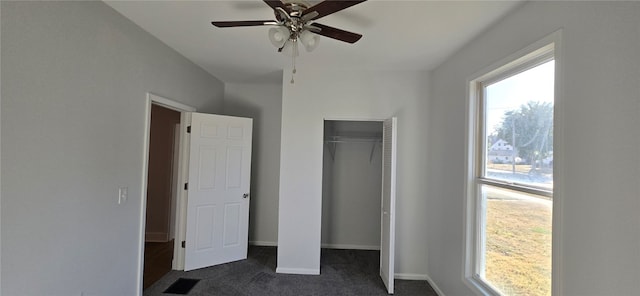 unfurnished bedroom with a closet, ceiling fan, and dark carpet