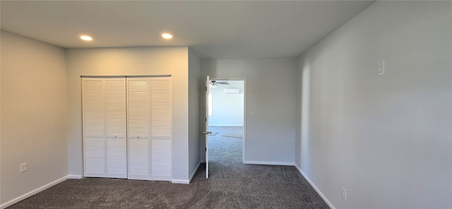 unfurnished bedroom with a closet and dark carpet