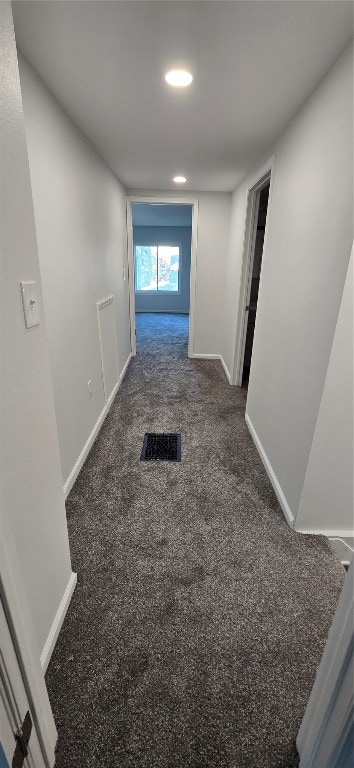 hall featuring dark colored carpet