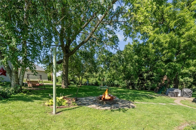 view of yard featuring an outdoor fire pit and a playground