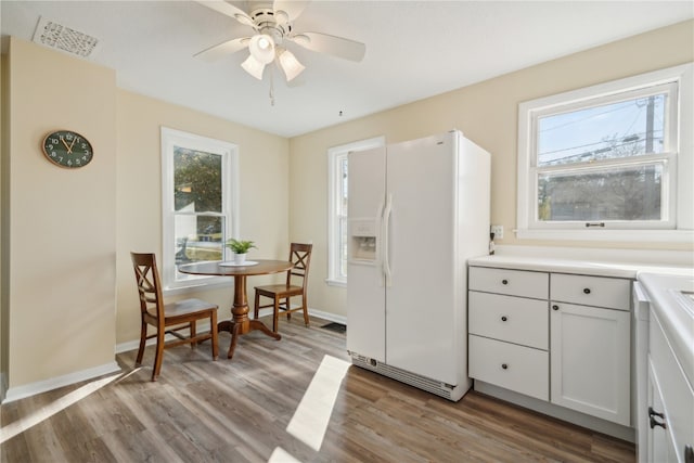 kitchen with white cabinets, ceiling fan, light hardwood / wood-style flooring, and white refrigerator with ice dispenser