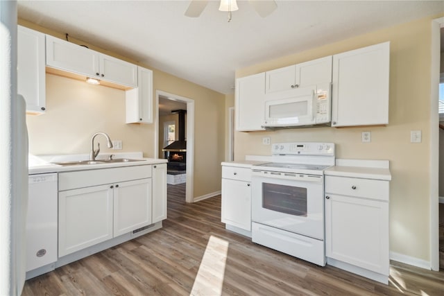 kitchen with white appliances, white cabinetry, sink, light wood-type flooring, and ceiling fan