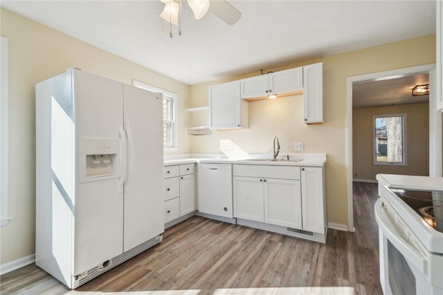 kitchen with white appliances, white cabinets, sink, light hardwood / wood-style flooring, and ceiling fan