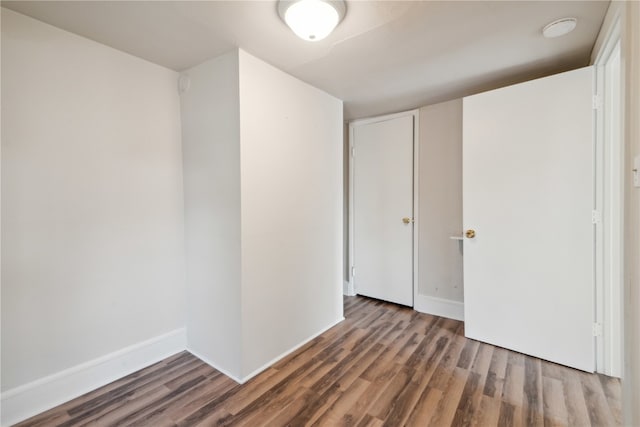 unfurnished room with dark hardwood / wood-style flooring