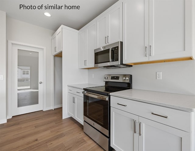 kitchen with stainless steel appliances, light wood-type flooring, and white cabinets