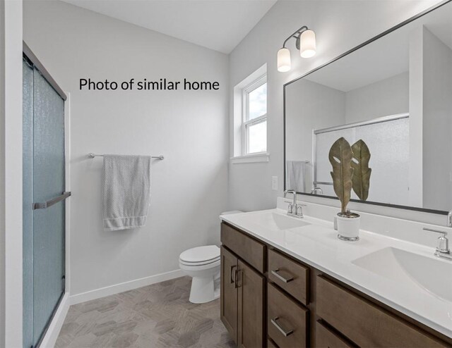 bathroom featuring vanity, toilet, and walk in shower