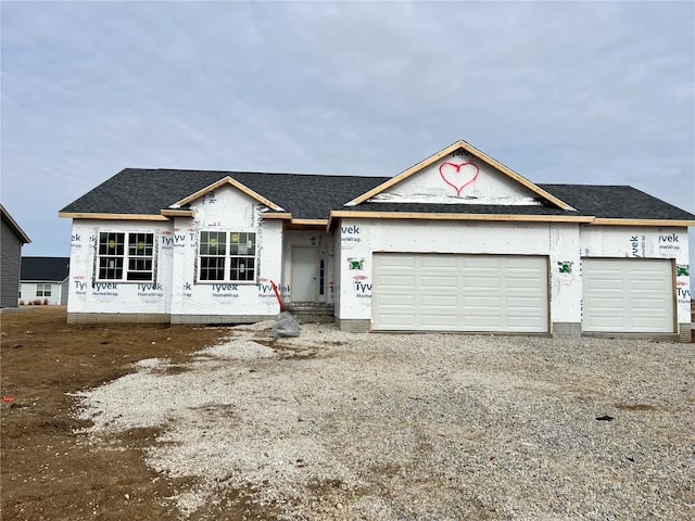 property in mid-construction with roof with shingles, an attached garage, and dirt driveway