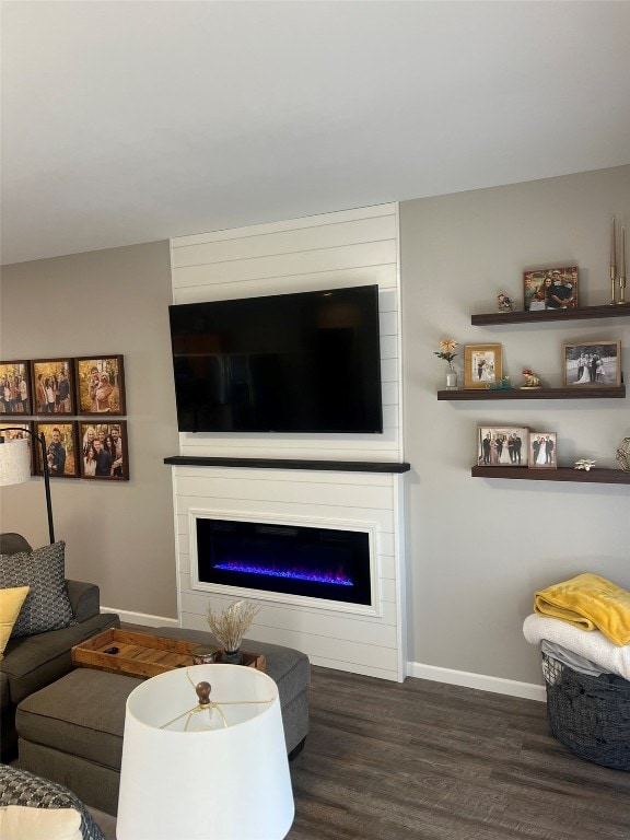 living room with dark wood-type flooring and a fireplace