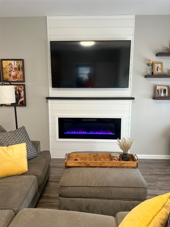 living room featuring dark hardwood / wood-style floors and a large fireplace