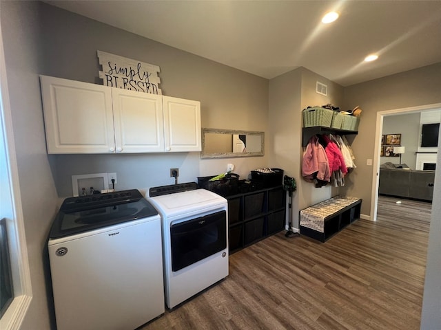 laundry area with cabinets, independent washer and dryer, and dark wood-type flooring