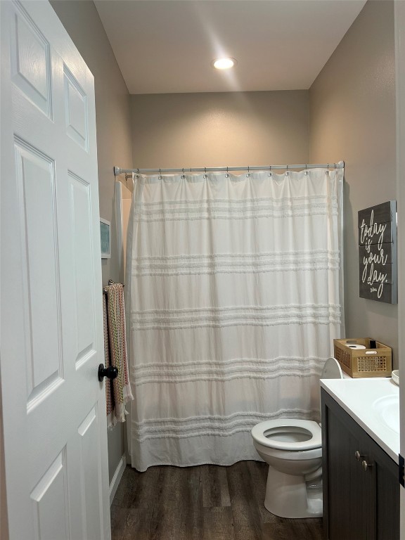 bathroom featuring vanity, walk in shower, hardwood / wood-style flooring, and toilet