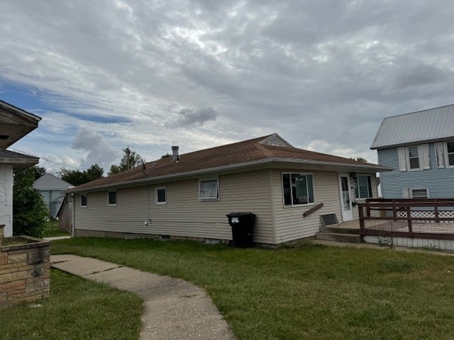 back of house featuring a deck and a lawn