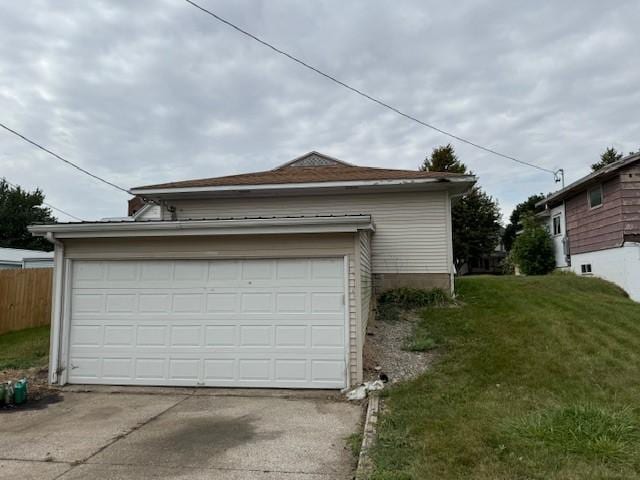 garage featuring driveway and fence
