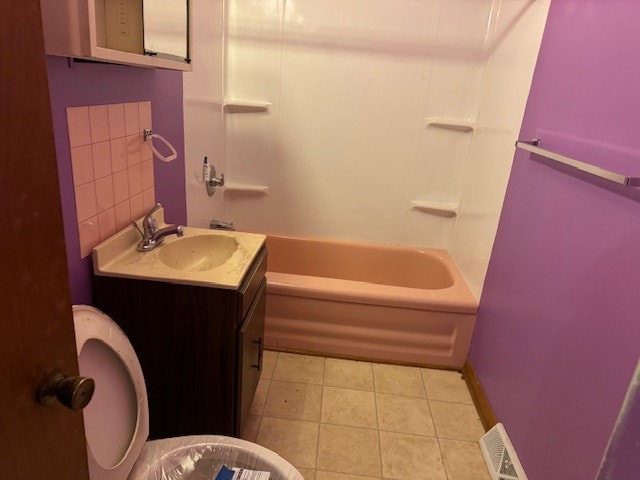 bathroom with vanity, tile patterned flooring, toilet, and tasteful backsplash