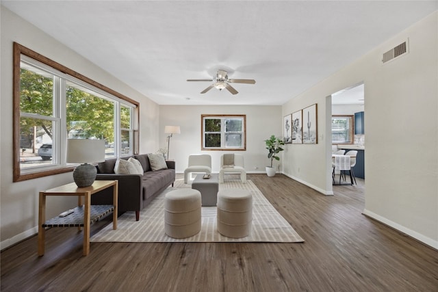 living room with dark wood-type flooring and ceiling fan